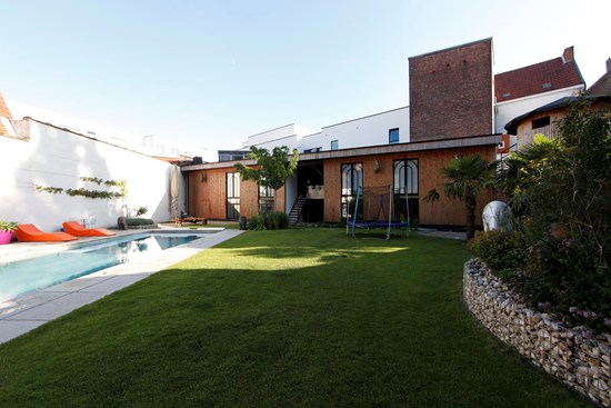 De weelderig groene tuin met verwarmd zwembad van Koto B&B in Antwerpen
